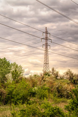  Industrial landscape. Old power transmission towers on a cloudy sky background