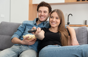 Young couple watching TV on sofa