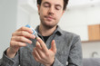 © Proxima Studio - Young man measures blood sugar level.