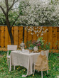Tables decorated in the spring garden for a photoshoot or wedding reception with lilac