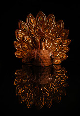  golden peacock statue isolated on dark background.