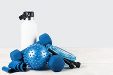 HealtHealthy Active Lifestyle Blue Gym Sports Accessories Grouped Around White Water Bottle Flask On White Grey Wood. Fitness And Exercise Monochrome Items Banner With Copy Space. Sports Club