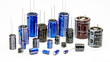 Electrolytic capacitors, many colors and sizes, white background, electronic component concepts