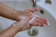 © HAMERCAT - To prevent a coronavirus pandemic, a girl washes her hands with soap and water, proper washing and handling of an antiseptic will protect against the virus.