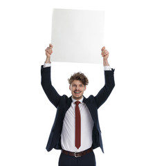 Cheerful businessman holding billboard above his head and celebrating