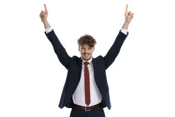 Happy businessman smiling and pointing up with both hands