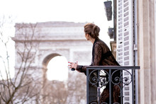 Attractive  yang Woman In Pajama Is Drinking Coffee On Balcony In The Morning In City Paris. View Of The Triumphal Arch.
