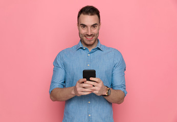 Poster - businessman texting on his phone, smiling and looking at camera