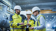 © Gorodenkoff - Three Heavy Industry Engineers Stand in Pipe Manufacturing Factory, Use Digital Tablet Computer, Have Discussion. Large Pipe Assembly. Design and Construction of Oil, Gas and Fuels Transport Pipeline