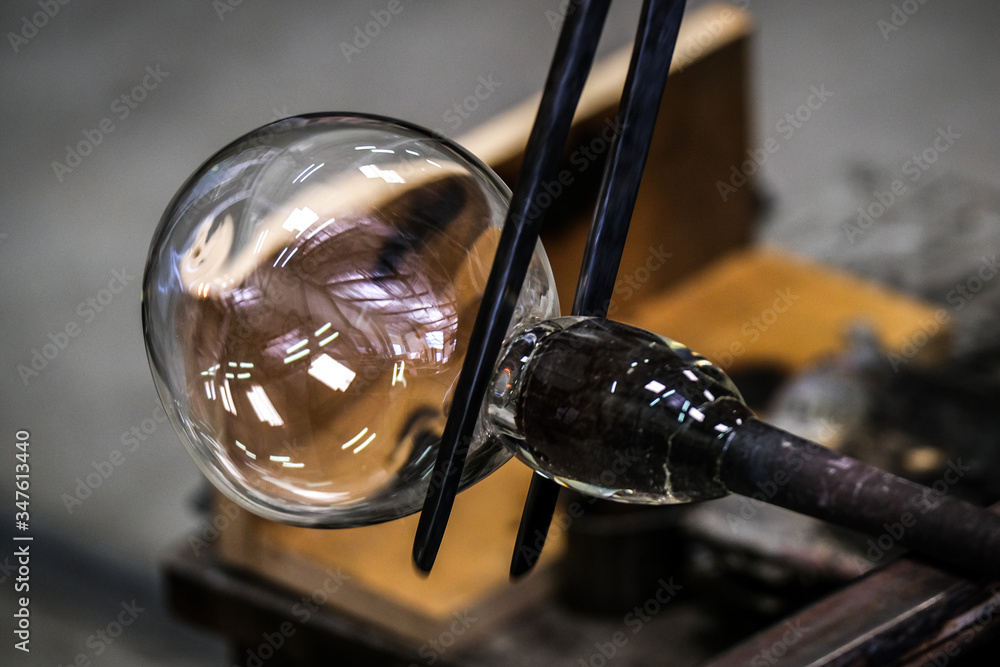 Artist glass blower working glass paste on his workbench. A glass ...