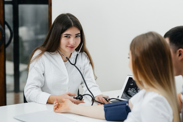 the doctor measures the pressure of a pregnant girl in the clinic. pregnancy, and health care