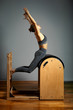© Georgii - Pilates, fitness, sport, training and people concept - woman doing exercises on a small barrel. Correction of impellent apparatus, correct posture.