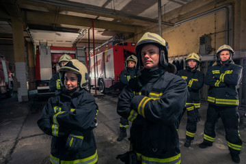 Wall Mural - Group of firefighters standing confident with arms crossed. Firemen ready for emergency service.