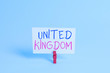 Conceptual hand writing showing United Kingdom. Concept meaning Island country located off the northwestern coast of Europe Colored clothespin rectangle shaped paper blue background
