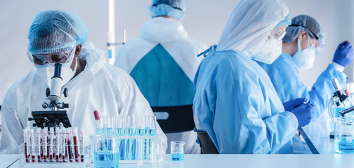 Wall Mural - african american biochemical research scientist and team working with microscope for coronavirus vac