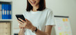 © sompong - Closeup of young woman hand holding smartphone and chatting with friends at social network.