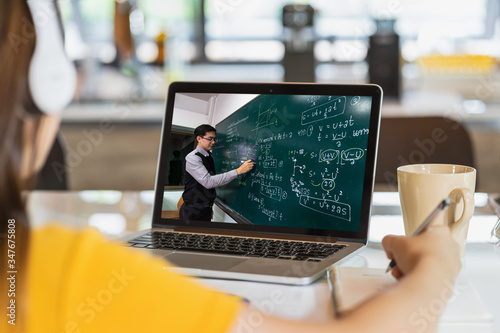 Fotomural Rear View of Asian student learning with teacher over the physics formular in th