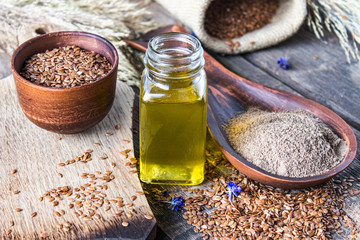 Wall Mural - Flaxseed oil in a bottle near the chopped flax seeds in a spoon.