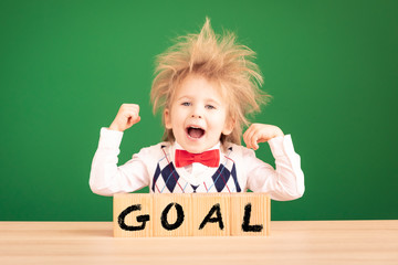 Bright idea! Happy child student against green chalkboard