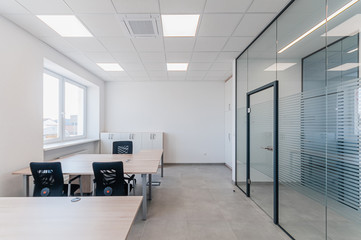 Wall Mural - Interior of small new empty office space with desks and chairs