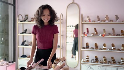 Wall Mural - attractive young woman choosing some shoes on the shelves on fashion store in the mall