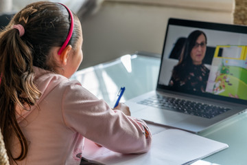 E-Learning concept. Young girl at elementary school following classes in distance learning. Coronavirus outbreak solutions