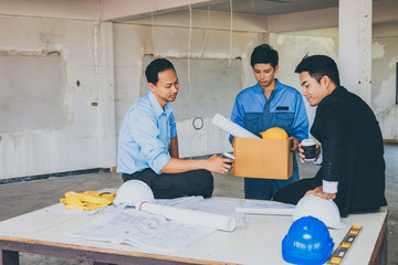 Engineer team and worker looking paper plans at construction site.