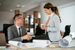 © JustLife - Businessman and businesswoman drinking coffee in office. Young man and woman having a coffee break.