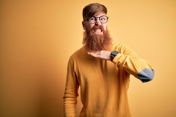 Sticker - Handsome Irish redhead man with beard wearing glasses over yellow isolated background cutting throat with hand as knife, threaten aggression with furious violence