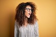 © Krakenimages.com - Young beautiful woman with curly hair and piercing wearing striped shirt and glasses angry and mad screaming frustrated and furious, shouting with anger. Rage and aggressive concept.