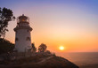 Shipping lighthouse on the seashore at sunrise