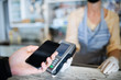 © Halfpoint - Contactless payment with smartphone, coffee shop open after lockdown.