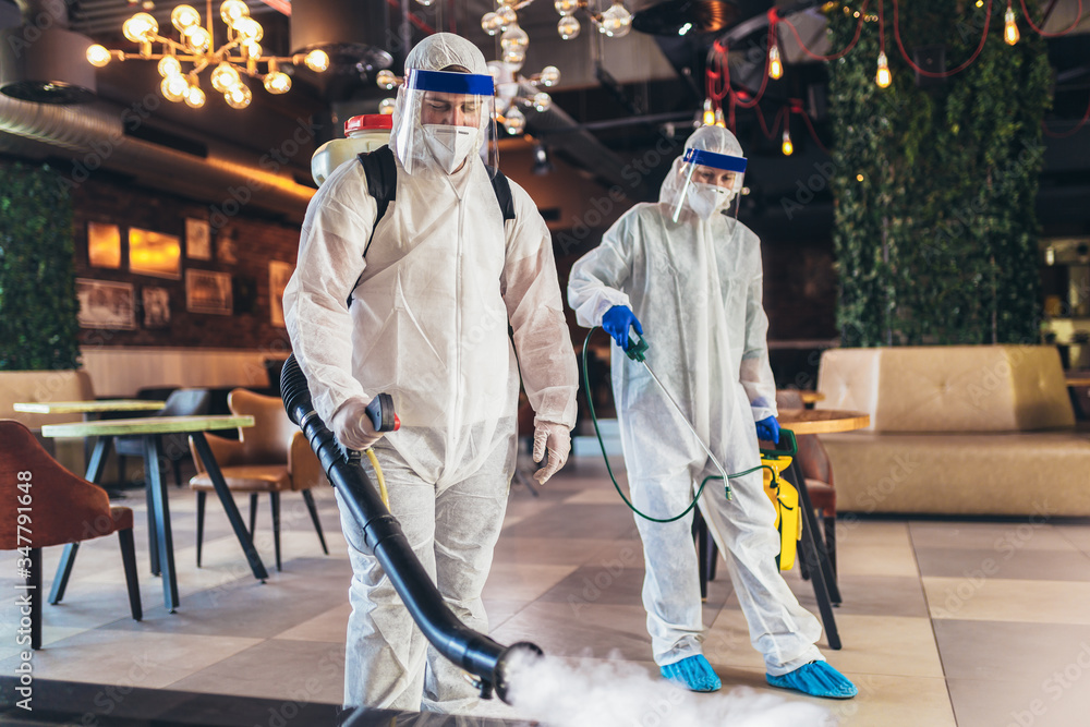 Professional workers in hazmat suits disinfecting indoor of cafe or restaurant, pandemic health risk, coronavirus - obrazy, fototapety, plakaty 