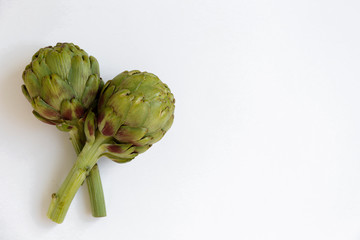 Wall Mural - Fresh green Italian Artichoke isolated on white background. Organic local produce vegetable on table top. Vegan diet. Clean eating concept. Close up, top view, flat lay.