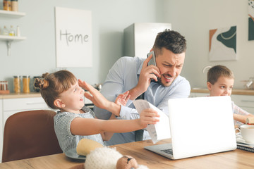 Canvas Print - Little children keeping father from his work at home