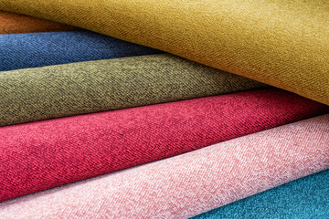 Many different colorful rolls of fabric