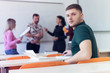 © as-artmedia - Young male economy student analyzing company annual financial report balance and prepairing for test. Smiling into camera. Concept of economy, education.