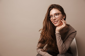 Photo of charming pleased woman smiling and sitting on chair