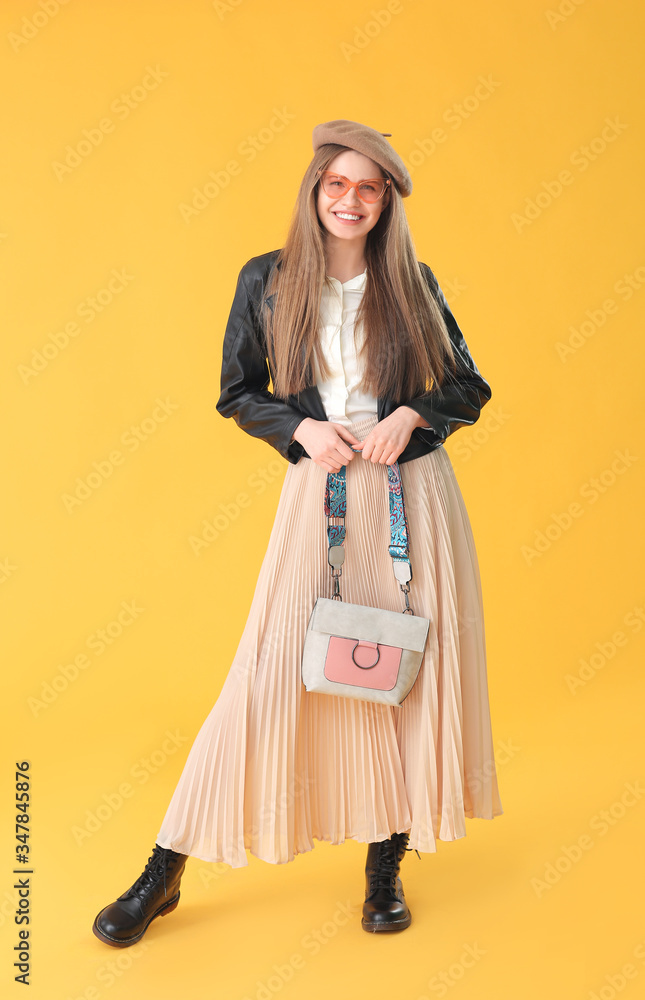 Beautiful woman with stylish bag on color background