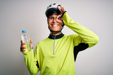 Poster - Young handsome cyclist man wearing security bike helmet drinking bottle of water with happy face smiling doing ok sign with hand on eye looking through fingers