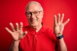 © Krakenimages.com - Grey haired senior man wearing glasses and casual t-shirt over red background showing and pointing up with fingers number nine while smiling confident and happy.