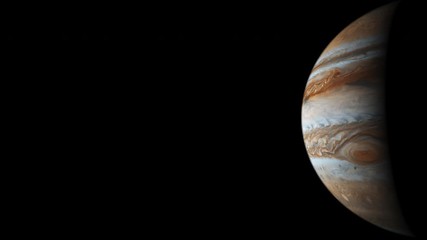 Wall Mural - slowly turning jupiter with the sun shining on one side of the gas giant in space concept