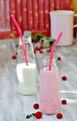 Wall Mural - Raspberry milk shake. Milkshake with raspberries in a bottle with a tube. A milky raspberry cocktail. Milk and raspberries are blended with a blender.