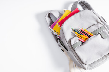 back to school concept. backpack with school supplies, pens, pencils, notebook on white background. 