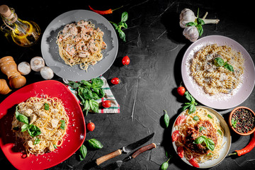 Wall Mural - Delicious Italian spaghetti pasta decorated with parsley, cheese and tomatoes on a dark background