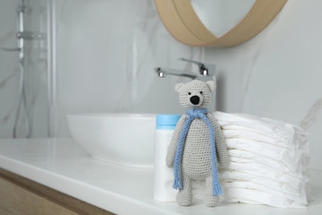 Wall Mural - stack of diapers and toy bear on counter in bathroom. space for text