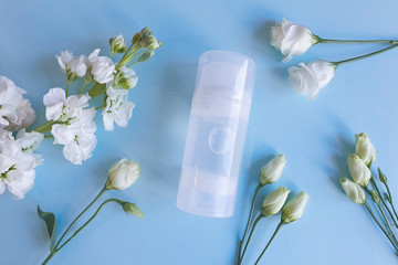 Mock up of transparent bottle of Intimate lubricant gel. Blue background with white flowers. Intimate massage, comfortable sex. Life style, flat lay.