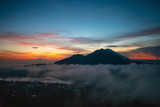 Fototapeta Góry - A panoramic landscape view of kintamani volcano from the top of the Mount Batur during the sunrise with fog