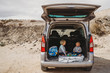 © Cavan Images - kids having a picnic in the trunk of their car during vacation holiday