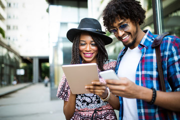 Young modern stylish couple using tablet in urban city